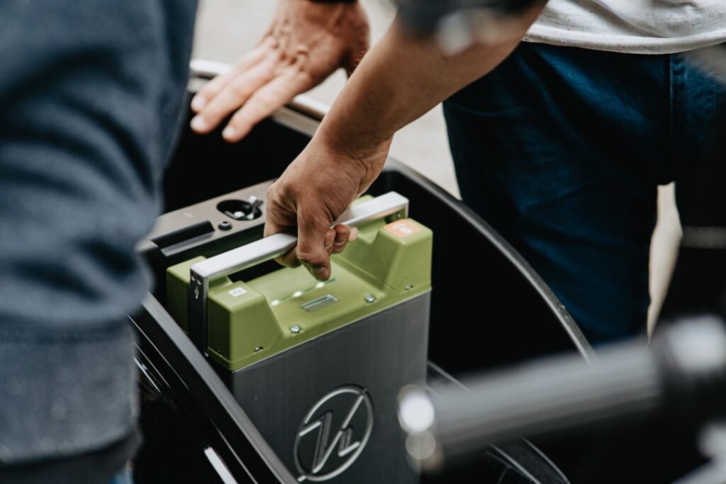A close-up of a motorcycle battery with tools and cleaning supplies nearby, emphasizing maintenance and care.