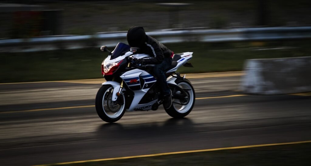 A motorcycle leaning into a curve on a scenic road, showcasing the dynamics of cornering.