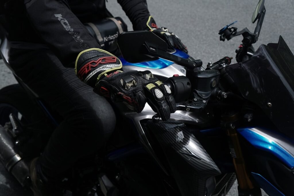 A close-up of a pair of motorcycle gloves on a bike handlebar, emphasizing protection and style.