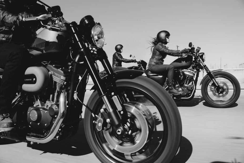 A group of motorcycle riders on a scenic road, showcasing camaraderie and teamwork while riding together.