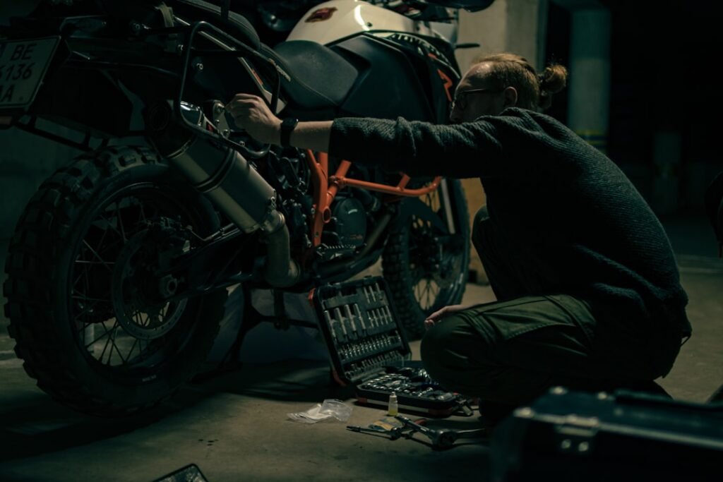 A close-up of a motorcycle tire with a focus on tread depth and wear indicators, set against a blurred background of a motorcycle.