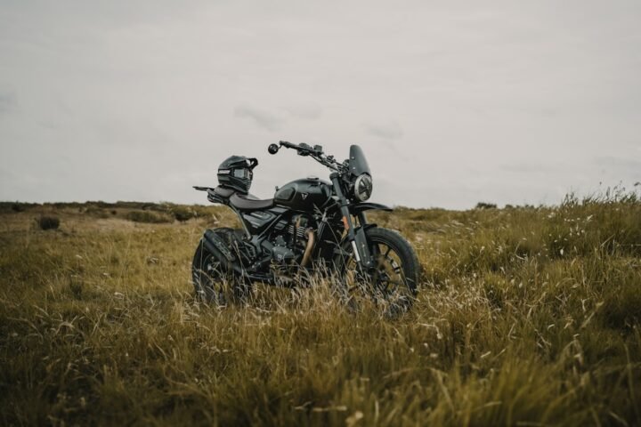 A scenic view of a winding road through mountains, with a motorcycle parked nearby, symbolizing adventure and travel planning.
