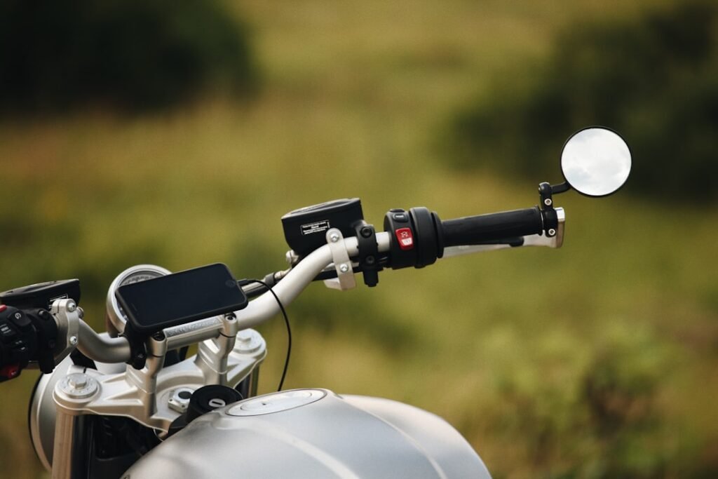 A close-up of a smartphone securely mounted on a motorcycle handlebar, showcasing the mount's design and functionality.