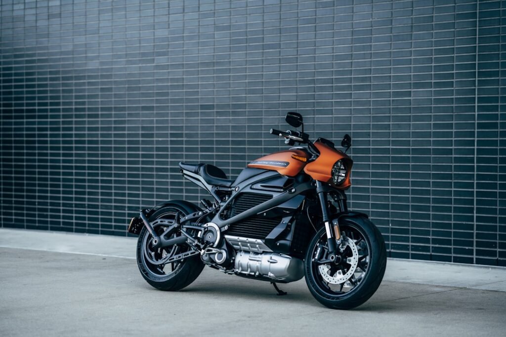 A motorcycle parked with charging equipment and accessories displayed nearby, showcasing various battery types and charging devices.