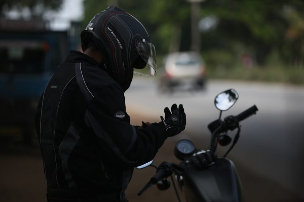 A close-up of a motorcycle jacket showcasing its protective features and materials, with a motorcycle in the background.
