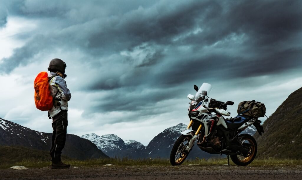A motorcycle rider wearing waterproof rain gear on a wet road, showcasing visibility and protection against the rain.