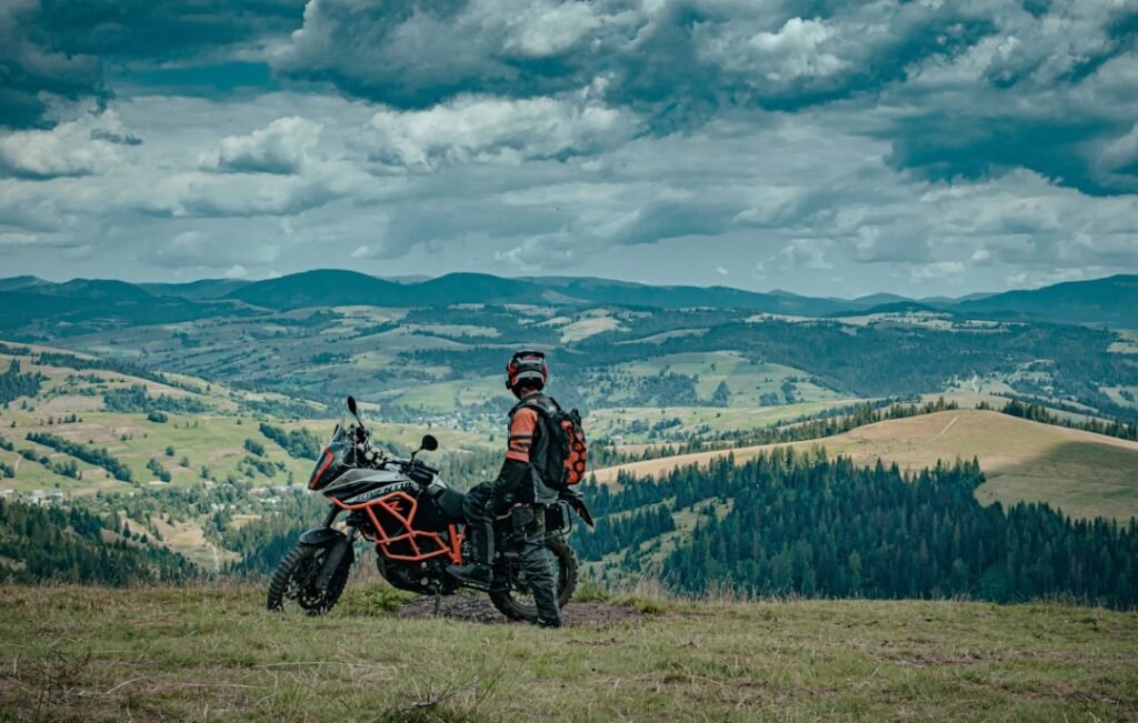 A scenic view of a motorcycle on a winding road through mountains, showcasing the freedom of touring.